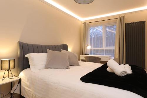 een slaapkamer met een groot wit bed met een raam bij Riverside serviced apartments in Londen