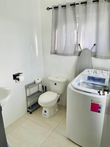 a white bathroom with a toilet and a sink at Salt St Lucia Villa in Vieux Fort