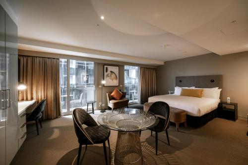 ein Hotelzimmer mit einem Bett, einem Tisch und Stühlen in der Unterkunft The Kinson in Melbourne