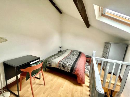 um quarto com uma cama, uma secretária e uma escadaria em Escapade Moretaine - 22 Langin em Moret-sur-Loing