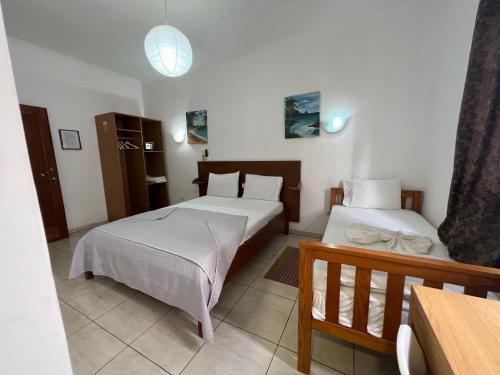 a bedroom with two beds and a table at Paradise Agua Leve Residential in São Tomé