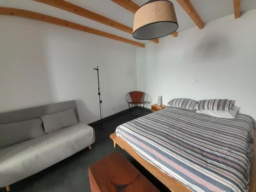 een slaapkamer met een bed en een bank bij Covil's Haus in Peniche