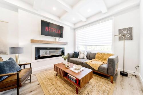 a living room with a couch and a fireplace at Nordic Retreat, 4BR, Min to WEM & DT, AirCon & Fireplace, Sleeps 10! in Edmonton