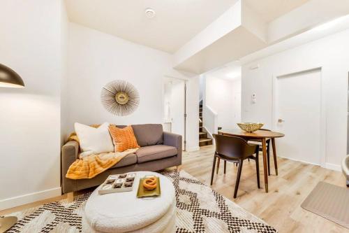 a living room with a couch and a table at Nordic Retreat, 4BR, Min to WEM & DT, AirCon & Fireplace, Sleeps 10! in Edmonton