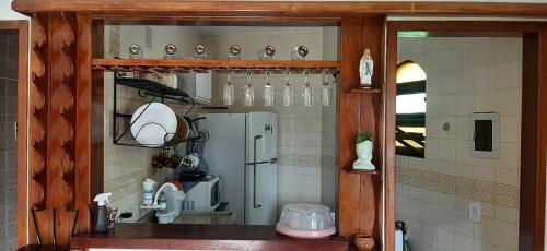 a kitchen with a counter with a refrigerator at Chalé Pé na Areia em Rio das Ostras in Rio das Ostras