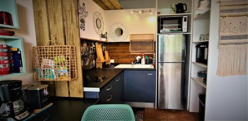 a small kitchen with a refrigerator and a sink at TITIRI Appartement in Les Trois-Îlets