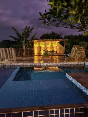a swimming pool in a backyard at night at Vila da Mata Chalés in Alto Paraíso de Goiás