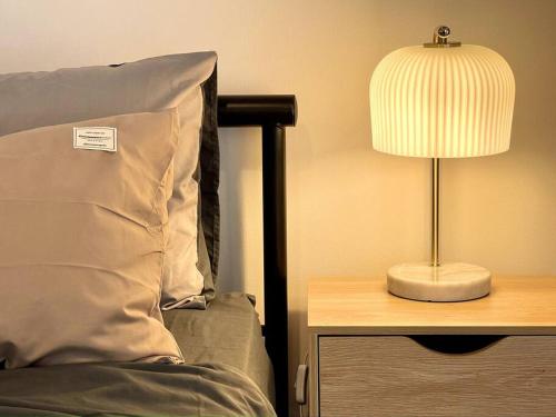 a lamp on a table next to a bed at Modern Studio with Mountain View and Near Airport & CBD in Warrane