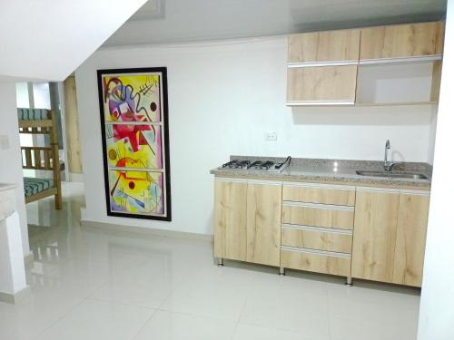 una cocina con fregadero y una pintura en la pared en Roatán, en Gaira