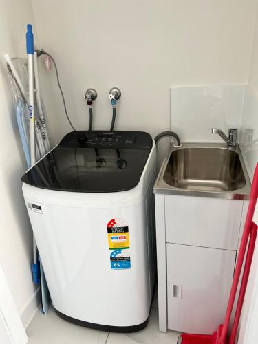 a small kitchen with a sink and a stove at Fragrant Home-68A Brand New 2 rooms House with beautiful private garden and entrance,5G wifi in Doonside
