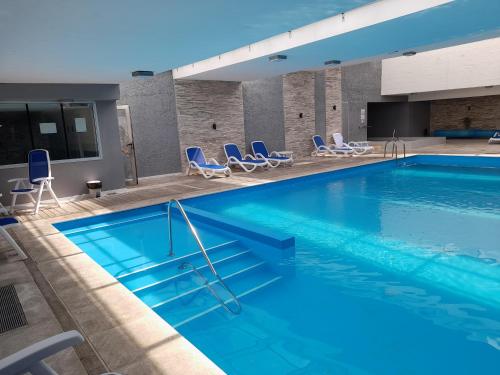 una gran piscina con sillas azules en un hotel en Look Brava Piso 17, en Punta del Este