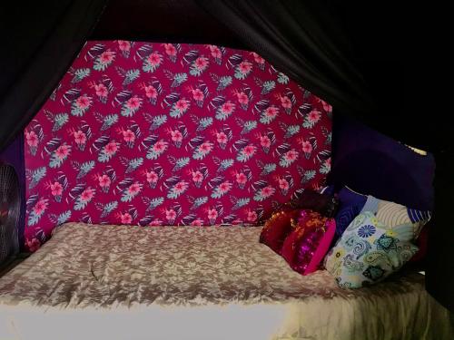 a small bed with a red head board and pillows at Beachfront Paradise in Manuel Antonio