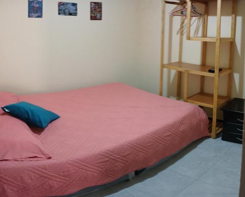 a bedroom with a bed with a pink blanket at Acogedor Apartamento en Centro de Popayán in Popayan