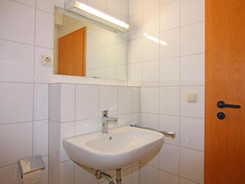 a white bathroom with a sink and a mirror at Resort Orther Reede, Fehmarn-Orth in Orth