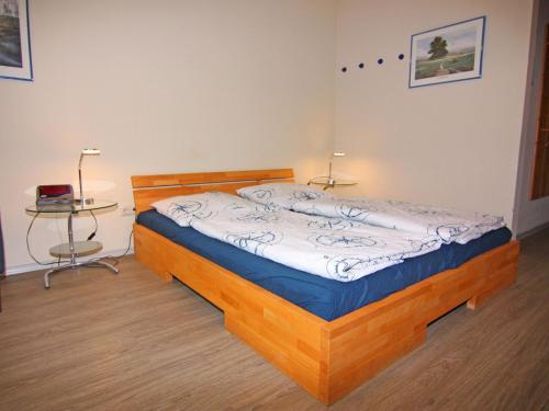 a bedroom with a wooden bed and a table at Resort Orther Reede, Fehmarn-Orth in Orth