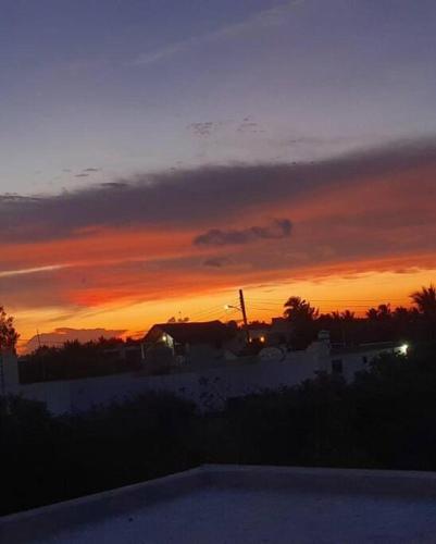 a sunset over a house with a pool in the foreground at Casa Calandria in Chicxulub