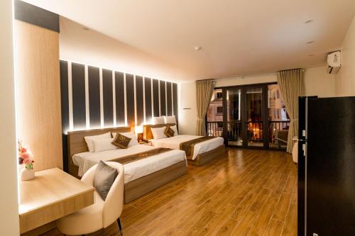 a hotel room with two beds and a couch at The One Hotel in Hai Phong
