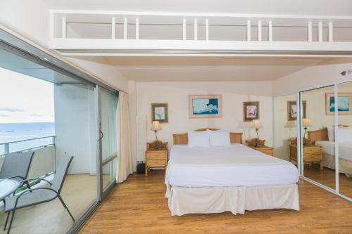 a bedroom with a bed and a balcony with the ocean at Ilikai Tower 1538 Lagoon View 1BR in Honolulu