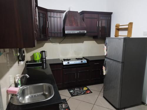a kitchen with a black refrigerator and a sink at Villa DEE DEE in Galle