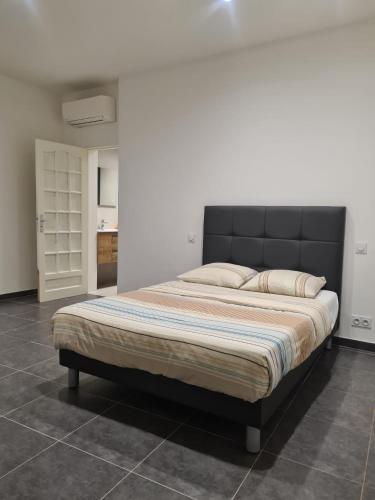 - un lit avec une tête de lit noire dans une chambre dans l'établissement Le Cedre Bleu, à Nice