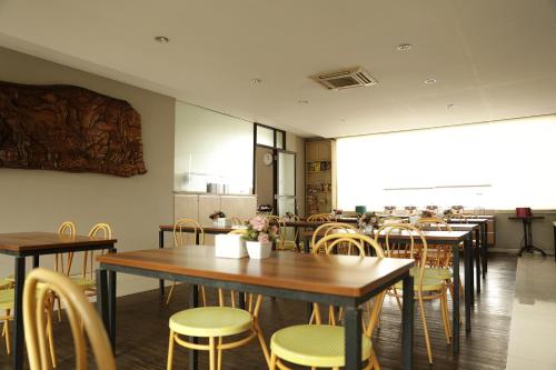 a restaurant with tables and chairs and a kitchen at Bale Ocasa in Tangerang