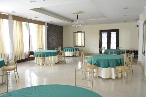 a banquet hall with green tables and chairs at Hotel Patrimonial by Greenfield in Guayaquil