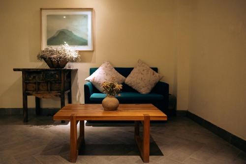 a living room with a blue couch and a table at The Apsara Lodge-Airport or TS Free pick-up over 3 nights in Yangshuo