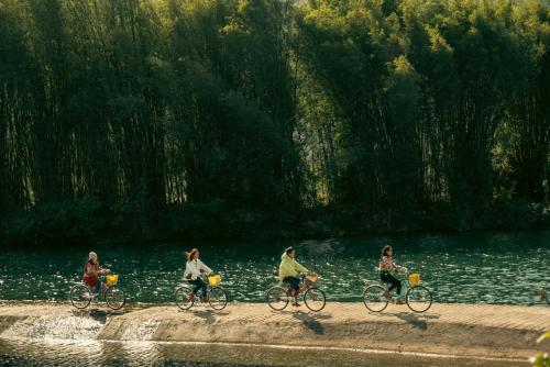 a group of people riding bikes by a body of water at The Apsara Lodge-Airport or TS Free pick-up over 3 nights in Yangshuo