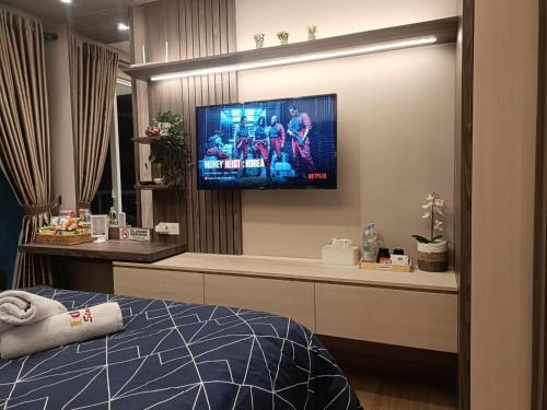 um quarto com uma televisão de ecrã plano na parede em Luxury Puri Mansion Apartment Kembangan em Jakarta