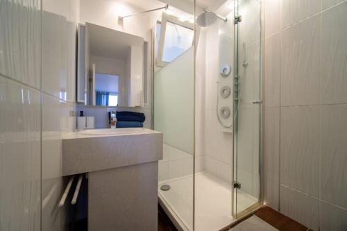 une salle de bain avec une douche en verre et un lavabo dans l'établissement Fully equipped apartment balcony sleeps 7 wifi, à Marseille