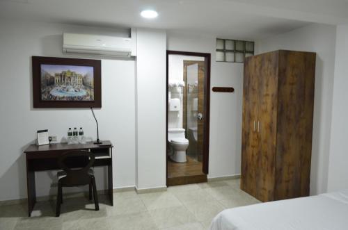 a bedroom with a desk and a bed and a bathroom at Hotel Patrimonial by Greenfield in Guayaquil