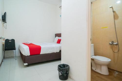 a bedroom with a bed and a shower and a toilet at RedDoorz near Flyover Arjosari Malang in Malang