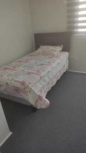 1 dormitorio con 1 cama con edredón rosado en Departamento sector florida, en La Serena