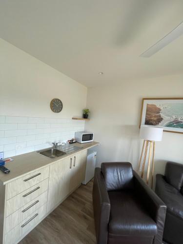 a kitchen with a sink and a chair in a room at Inverloch Motel in Inverloch