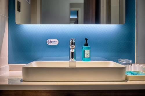 a bathroom sink with a bottle of soap on it at Holiday Inn Express Taian City Center by IHG in Tai'an
