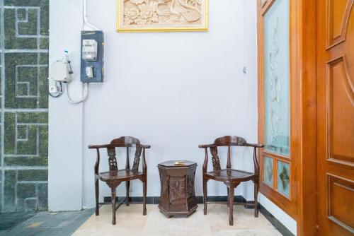 Dos sillas y un cubo de basura en una habitación en RedDoorz near Matahari Singosaren Solo, en Solo