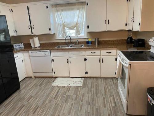 a kitchen with white cabinets and a sink at 3BR 2min from I-40,near DT, 21 min Palo Duro in Amarillo