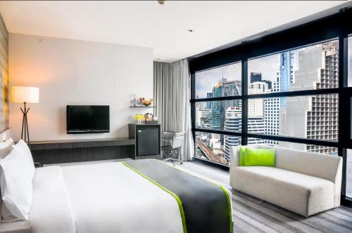 a hotel room with a bed and a large window at Holiday Inn Bangkok Sukhumvit by IHG in Bangkok