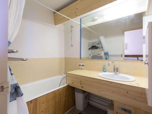 een badkamer met een wastafel, een bad en een spiegel bij Studio La Mongie, 1 pièce, 5 personnes - FR-1-404-343 in Bagnères-de-Bigorre
