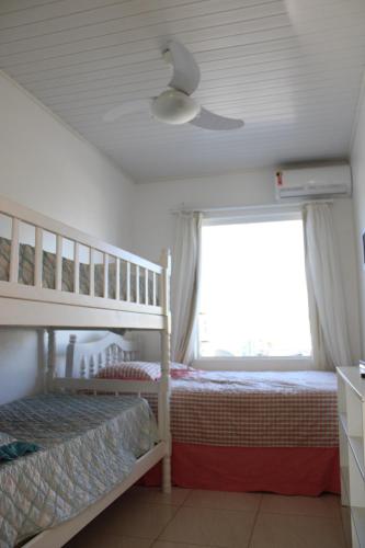een slaapkamer met een stapelbed en een plafondventilator bij Apartamento em Torres in Torres