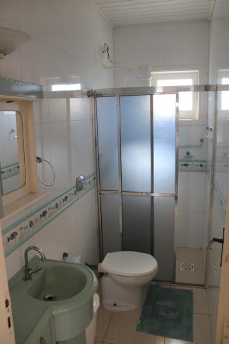een badkamer met een groene wastafel en een toilet bij Apartamento em Torres in Torres
