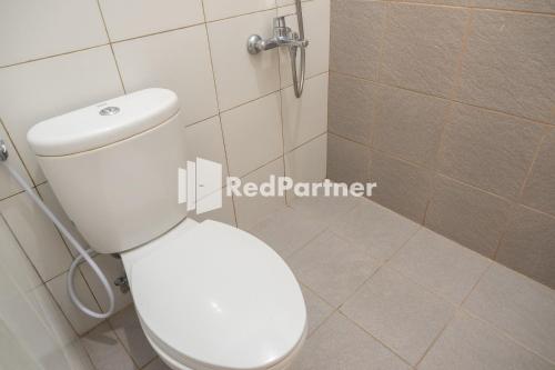 een badkamer met een wit toilet en een douche bij Twin House near UII Yogyakarta Mitra RedDoorz in Yogyakarta