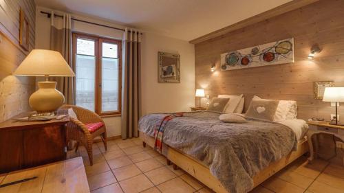a bedroom with a bed and a desk with a lamp at Panoramic Village - Locations vue Glaciers - Chez Philippe in La Grave