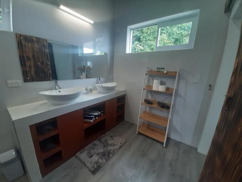ein Badezimmer mit 2 Waschbecken und einem Spiegel in der Unterkunft Mai'i Villa 1 - Muri in Avarua