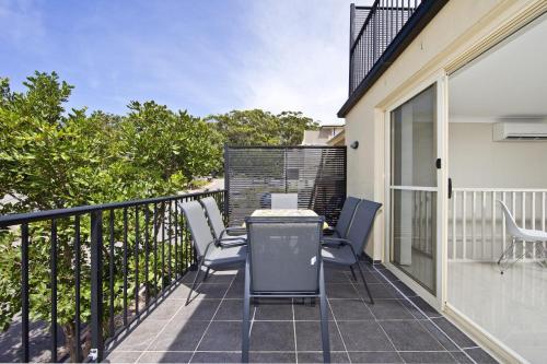 a patio with chairs and a table on a balcony at Aqua Lagoon - Great Family Beach Getaway in Nelson Bay