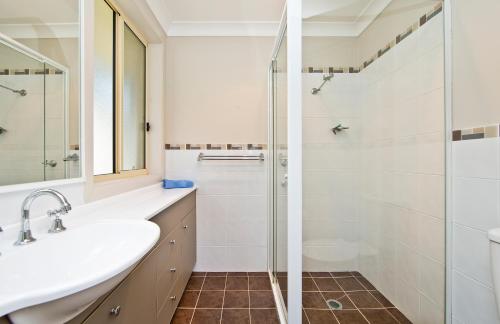 een badkamer met een wastafel en een douche bij Aqua Lagoon - Great Family Beach Getaway in Nelson Bay