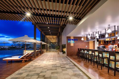 ニャチャンにあるVinpearl Beachfront Nha Trangのバーとプール付きのレストラン