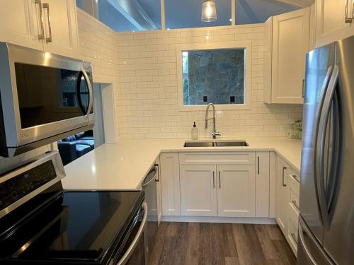 a white kitchen with a sink and a microwave at Escape to Spring Gate Estate in Victoria