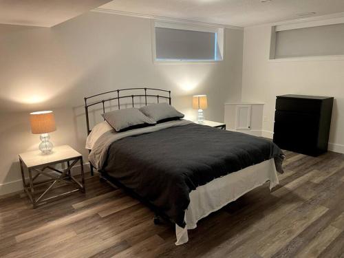 1 dormitorio con 1 cama y 2 mesas con lámparas en Escape to Spring Gate Estate, en Victoria