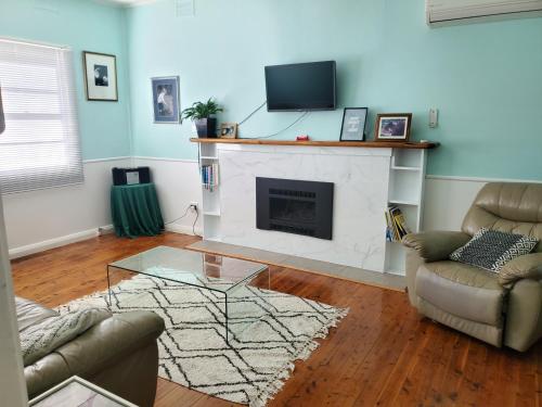 a living room with a fireplace and a tv at Coco's Cottage in Tamworth
